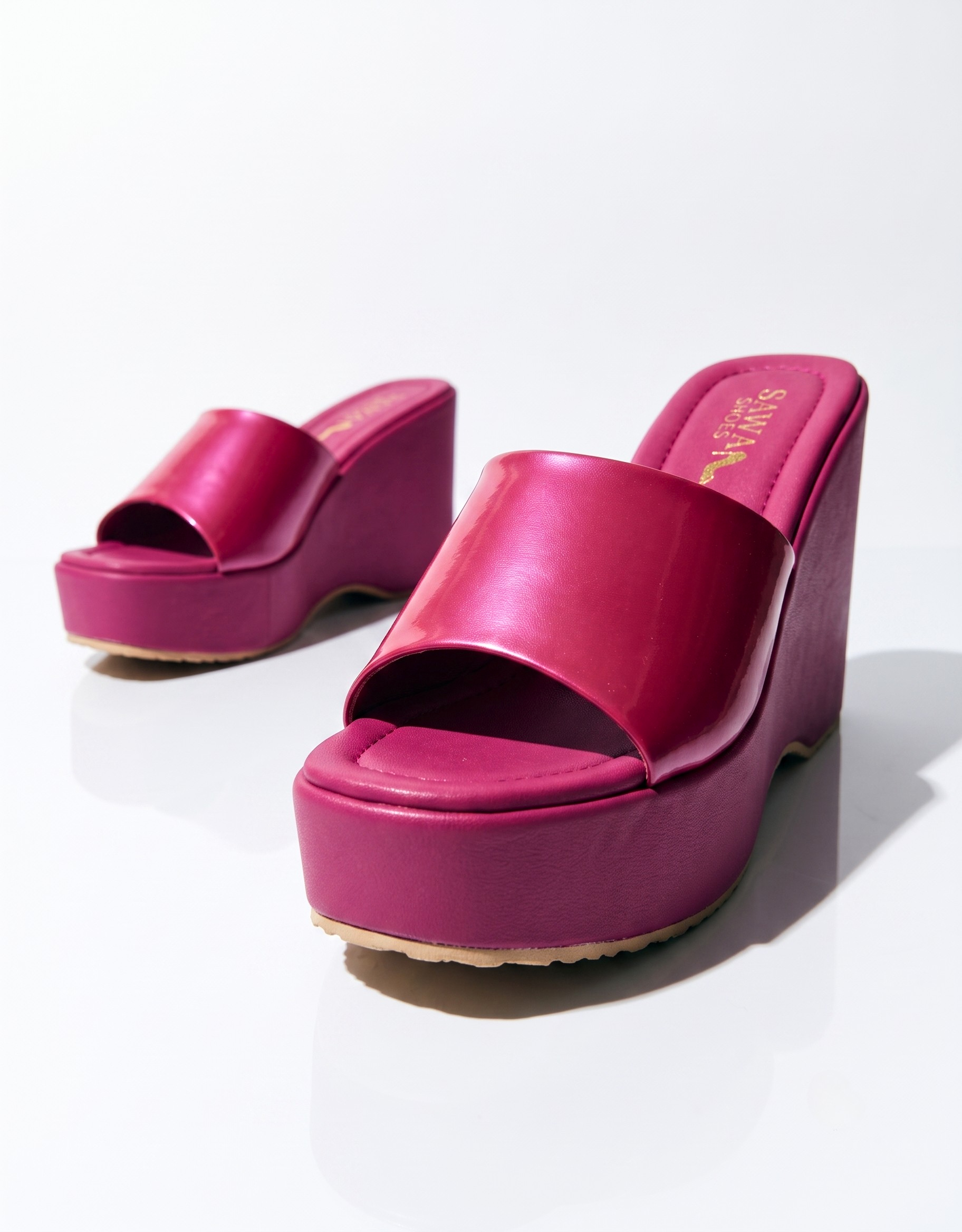 Fuchsia pink women’s platform wedge heels with a glossy wide strap, cushioned footbed and supportive slip-on design