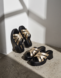 Women’s golden strappy block heels with a cushioned black footbed and sturdy platform sole