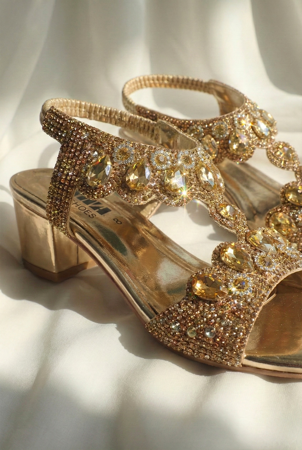 Side view of metallic gold block heel sandal featuring rhinestone straps and comfortable 2-inch heel for bridal wear.