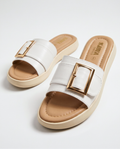 White slip-on platform slide sandal with a tan padded footbed and prominent gold buckle accent.