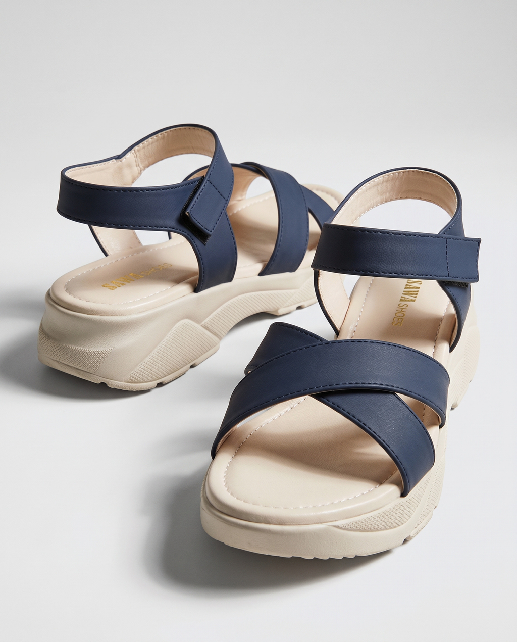 Navy blue strappy platform sandals with criss-cross front straps, adjustable ankle strap, and a chunky beige sole