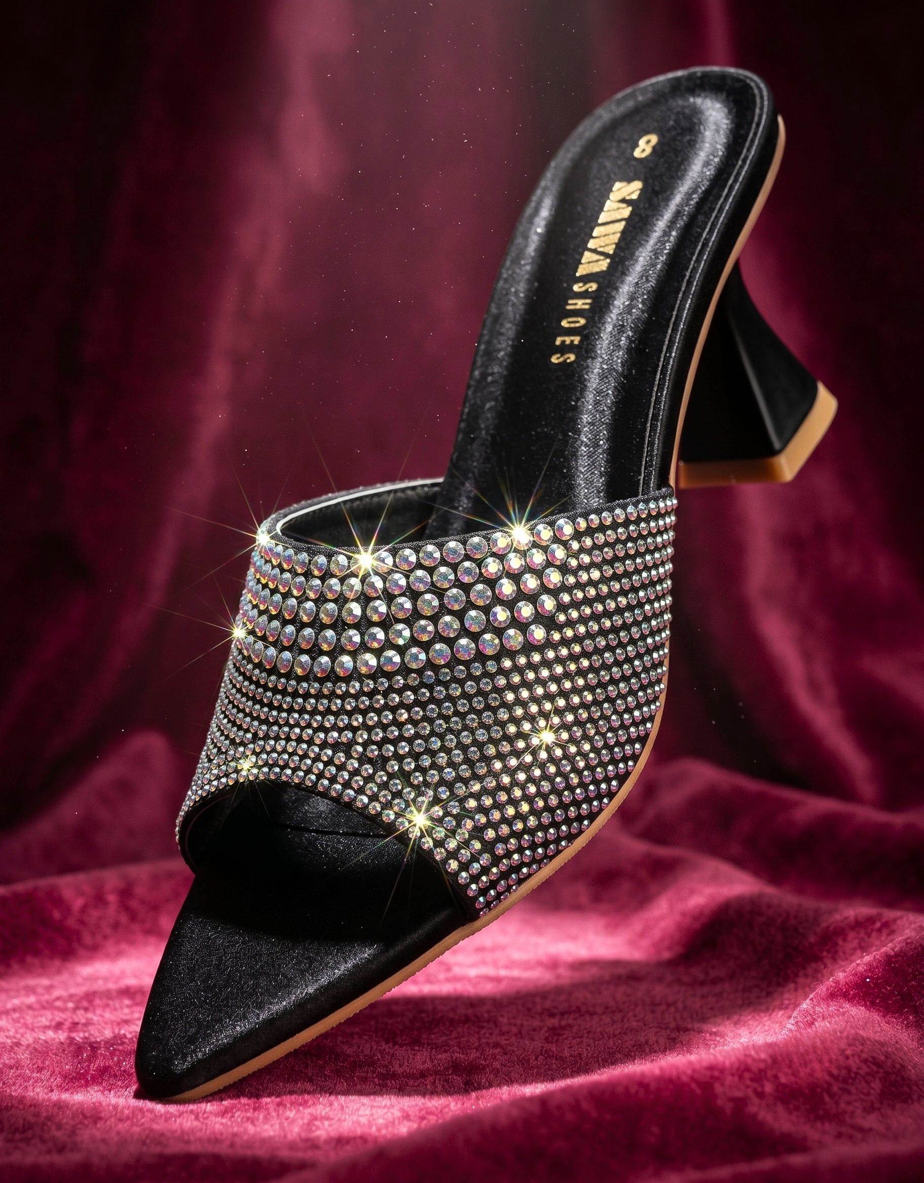 Black studded high-heeled shoe on a red fabric background