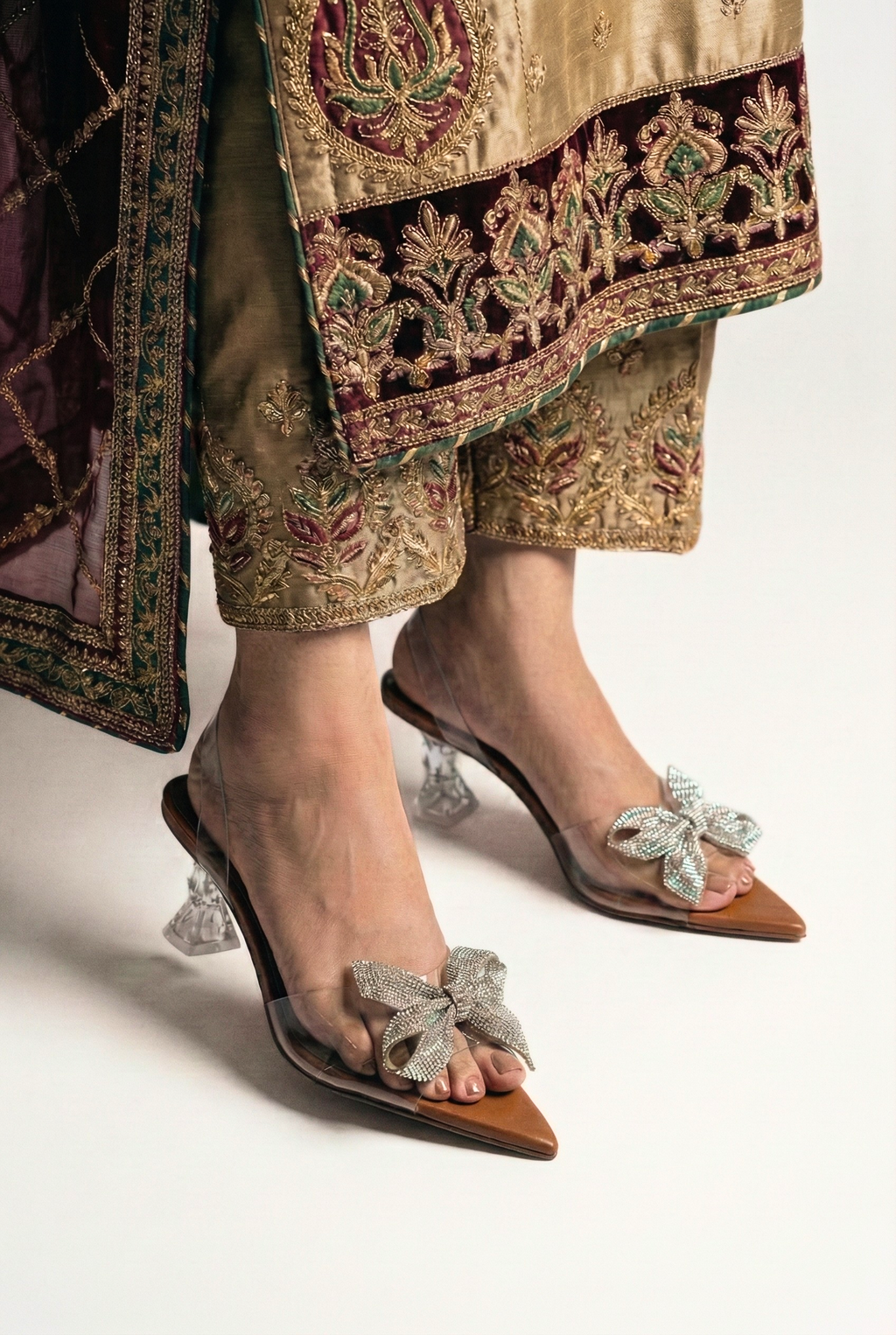 Side view of model wearing clear Cinderella heels showing architectural heel design and tan sole