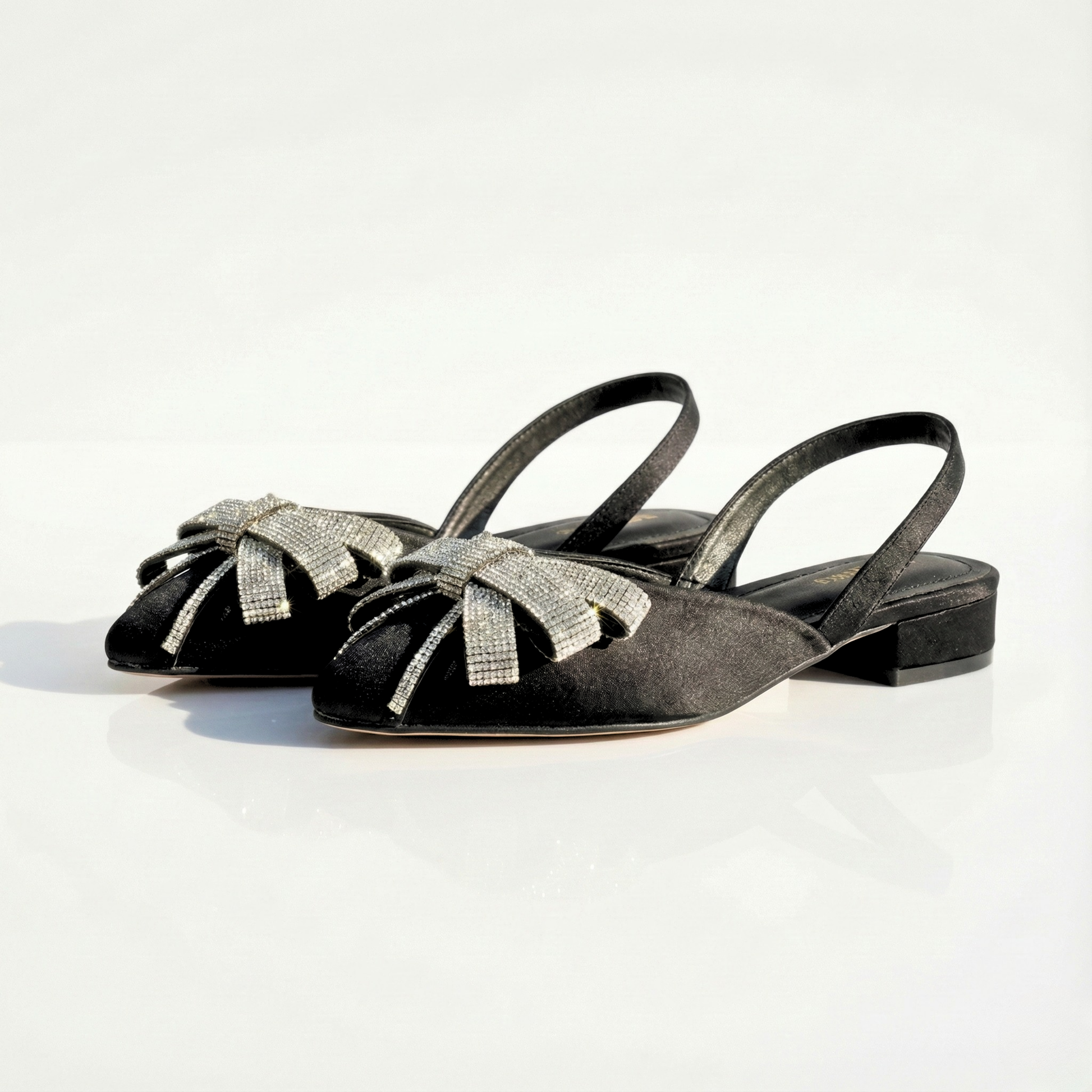 Side view of black satin ladies' pumps featuring a low block heel and elasticized slingback strap