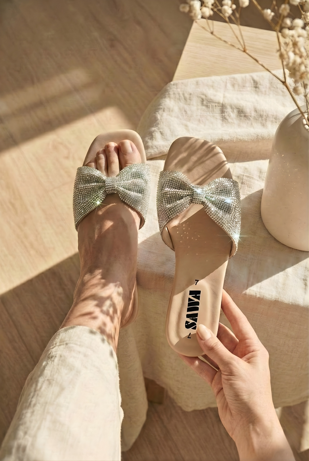 SAWA silver crystal bow flat sandals on feet, fancy stone work slides for ladies in Pakistan, ideal for wedding and party wear