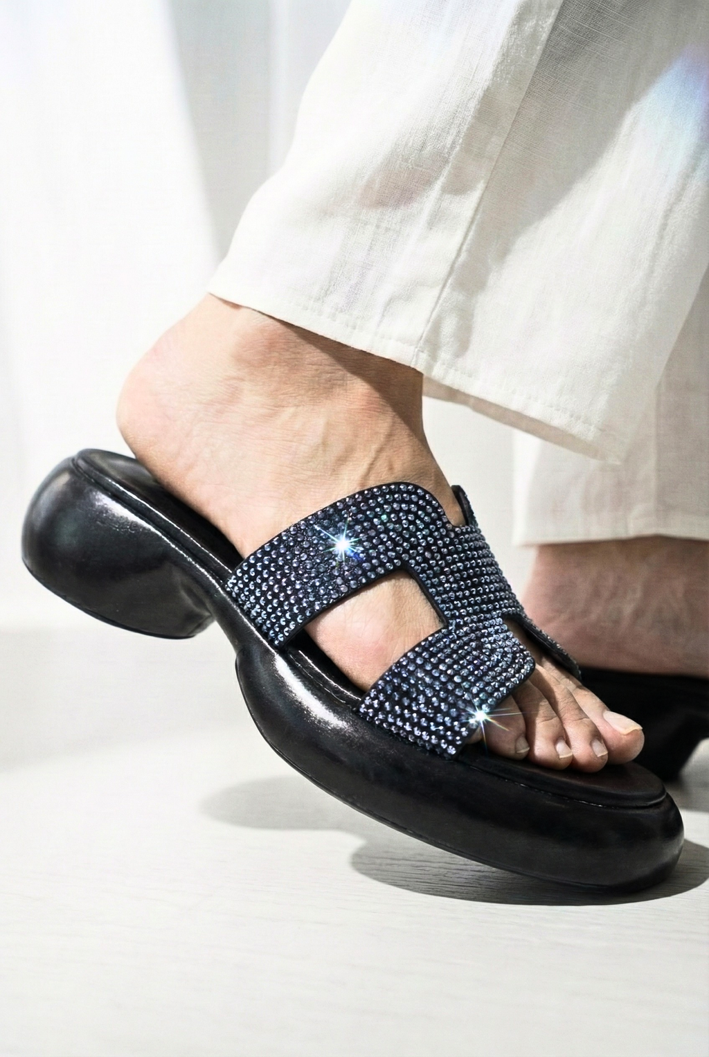 Side view of black Sawa shoes jeweled platform sandals showing ergonomic contoured heel and sparkle detail