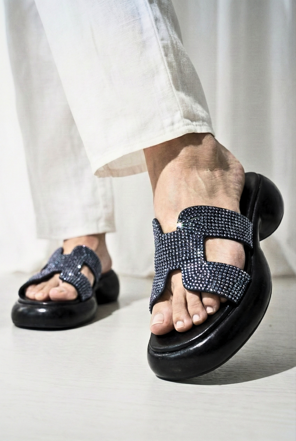 Black platform slides with crystal-encrusted H-strap and chunky sole for women in Pakistan