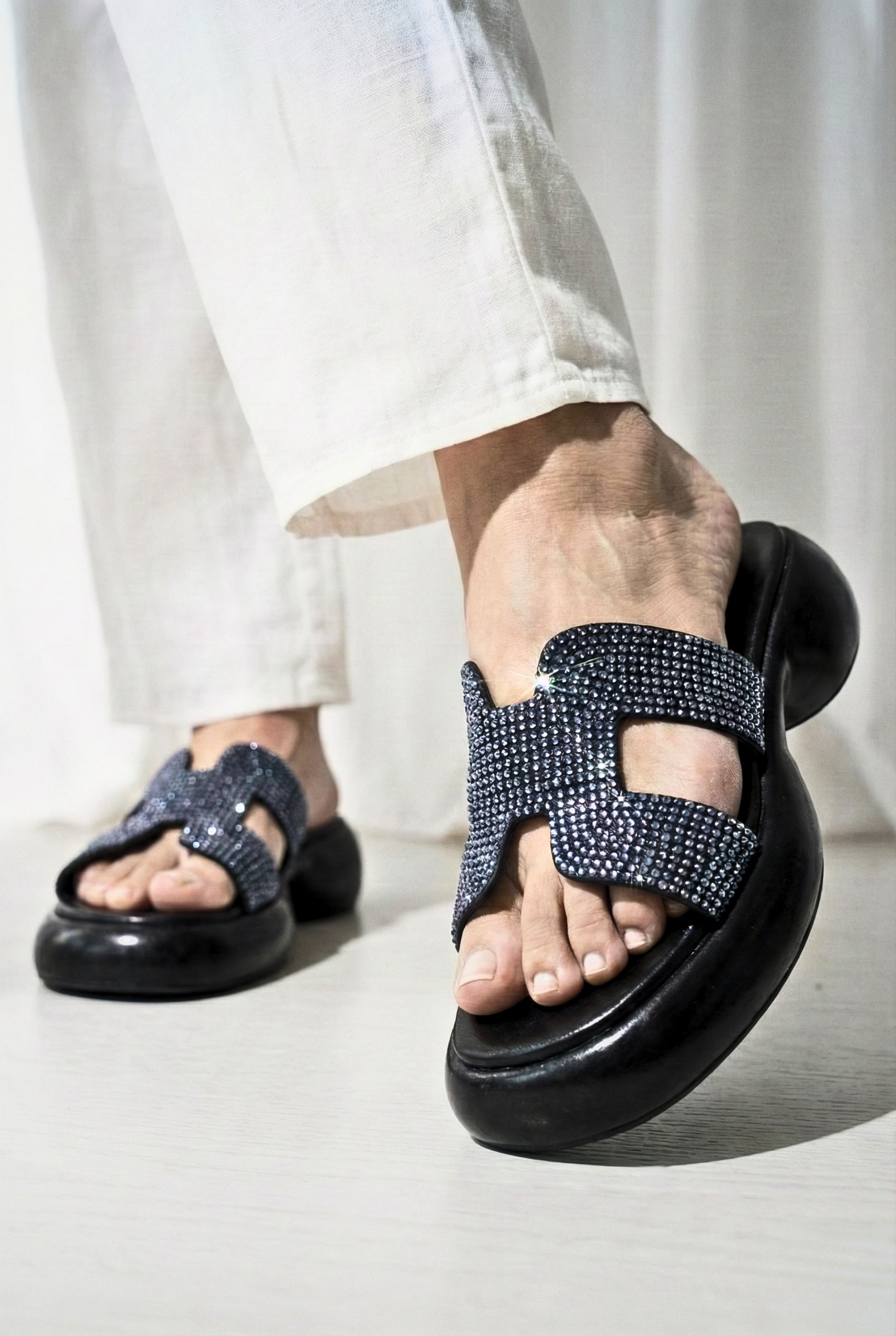 Black platform slides with crystal-encrusted H-strap and chunky sole for women in Pakistan