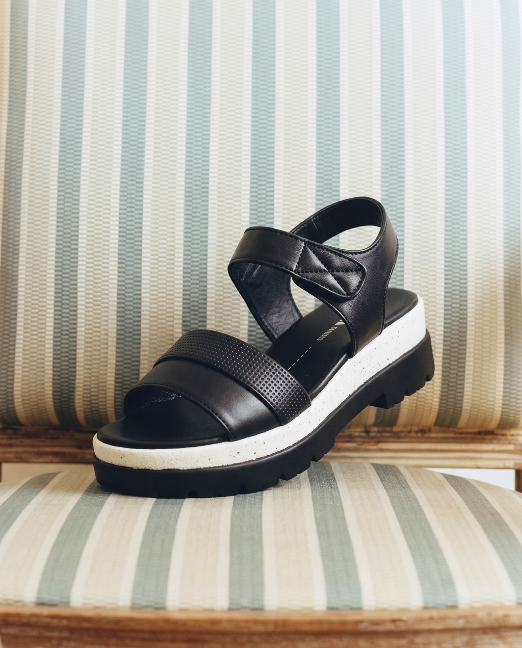 Black women’s platform sandals with textured front straps, adjustable ankle fastening and a black-and-white chunky sole