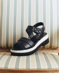 Black women’s platform sandals with textured front straps, adjustable ankle fastening and a black-and-white chunky sole