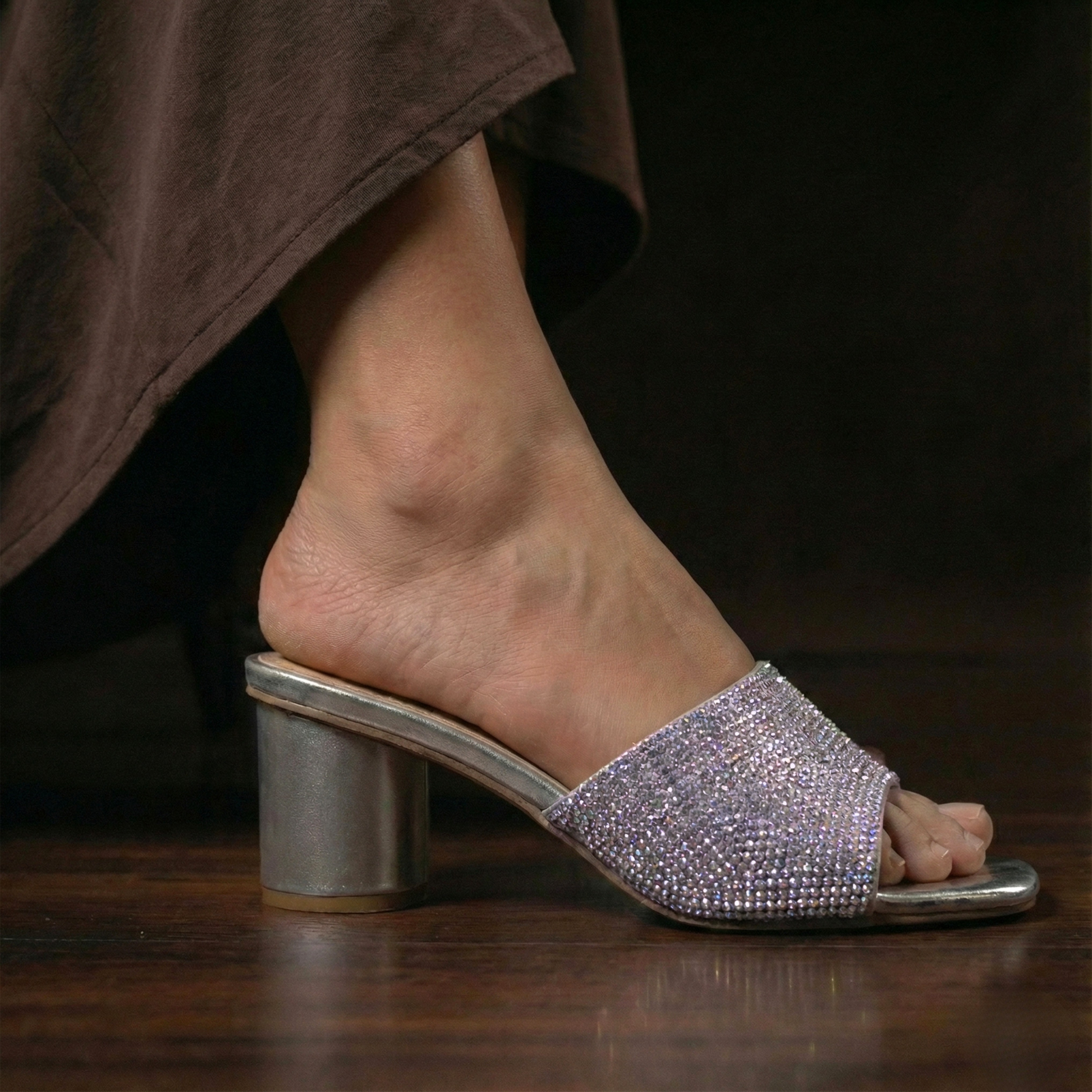 chrome silver mule sandal featuring a cylindrical block heel and rhinestone embellishments