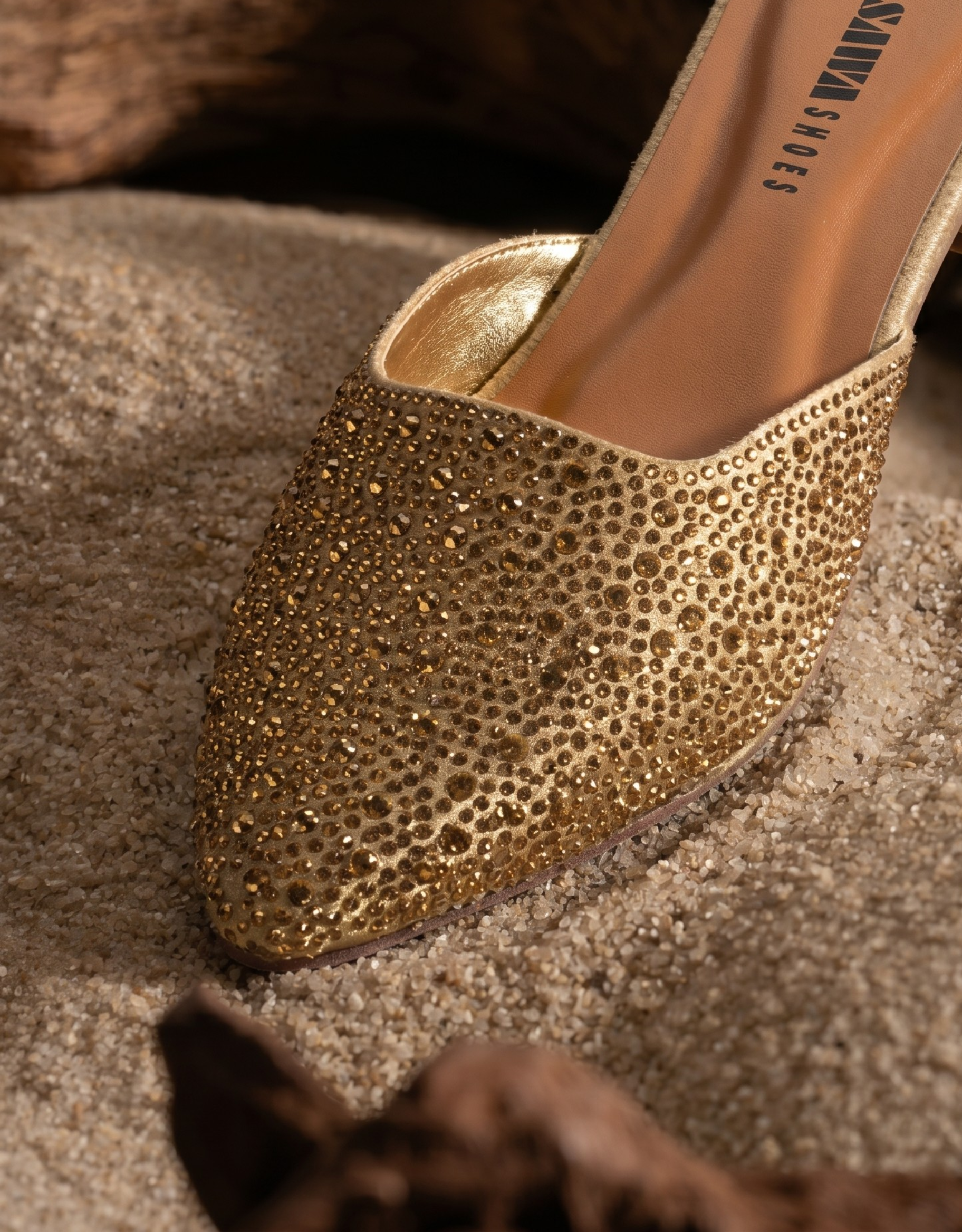 Gold glittery high-heeled shoe on a textured surface