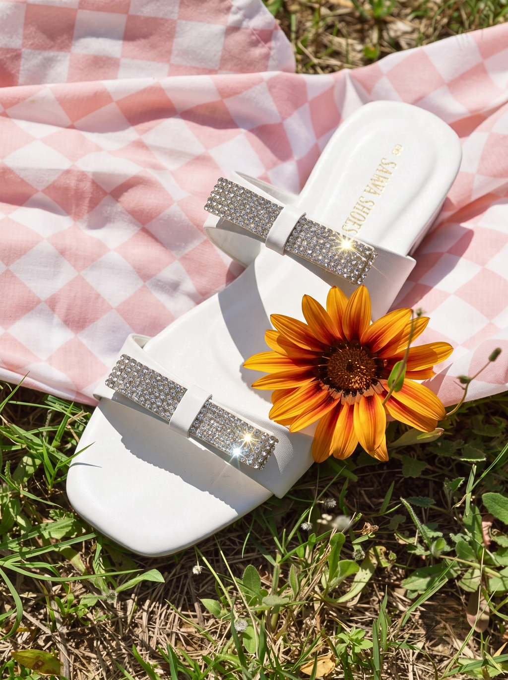White rhinestone bow slides for women on pink picnic cloth