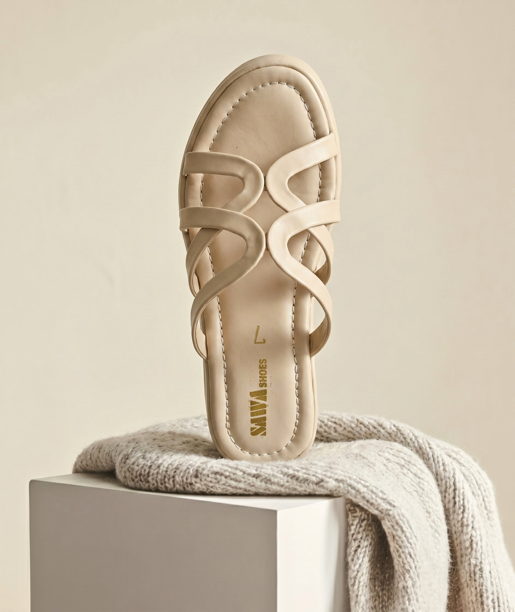 Beige sandal on a white block with a beige background