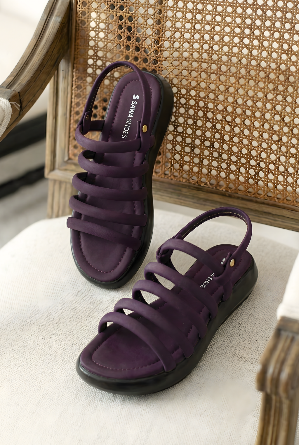 Close-up detail of purple puffy tube straps on ladies sandals with black flatform sole
