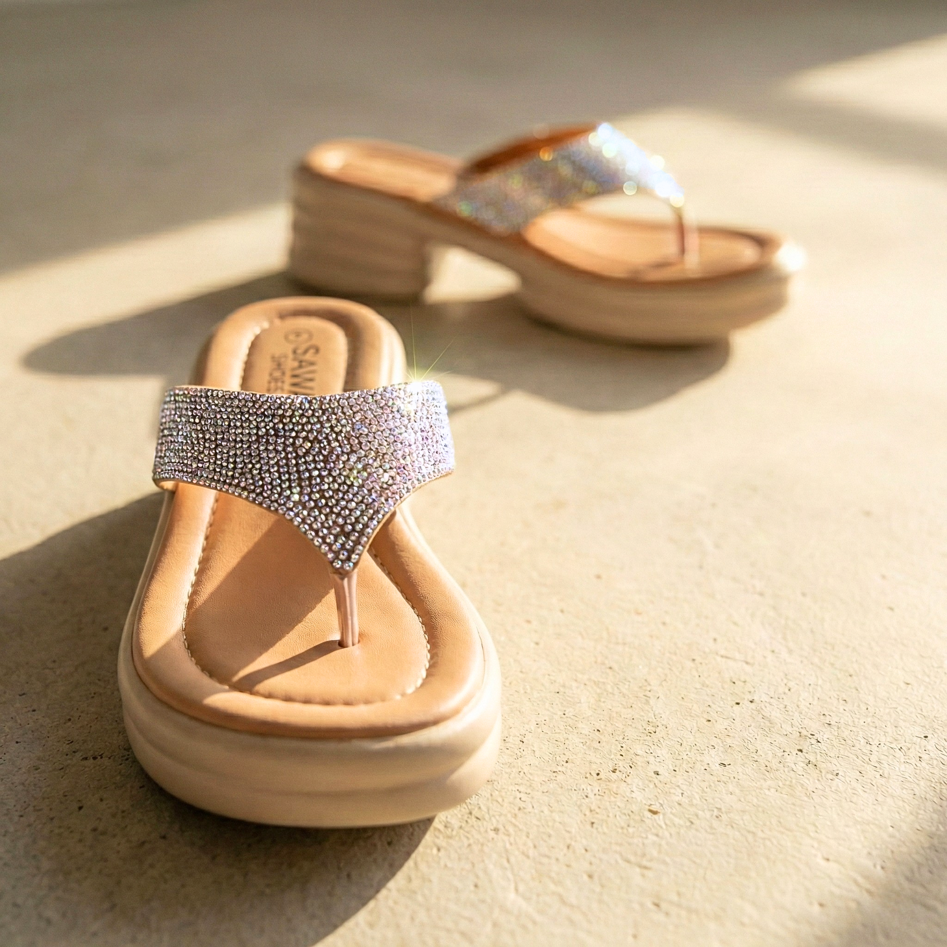 Close-up of Champagne Cloud Walk sandals featuring sparkling crystal-encrusted straps and a padded footbed.