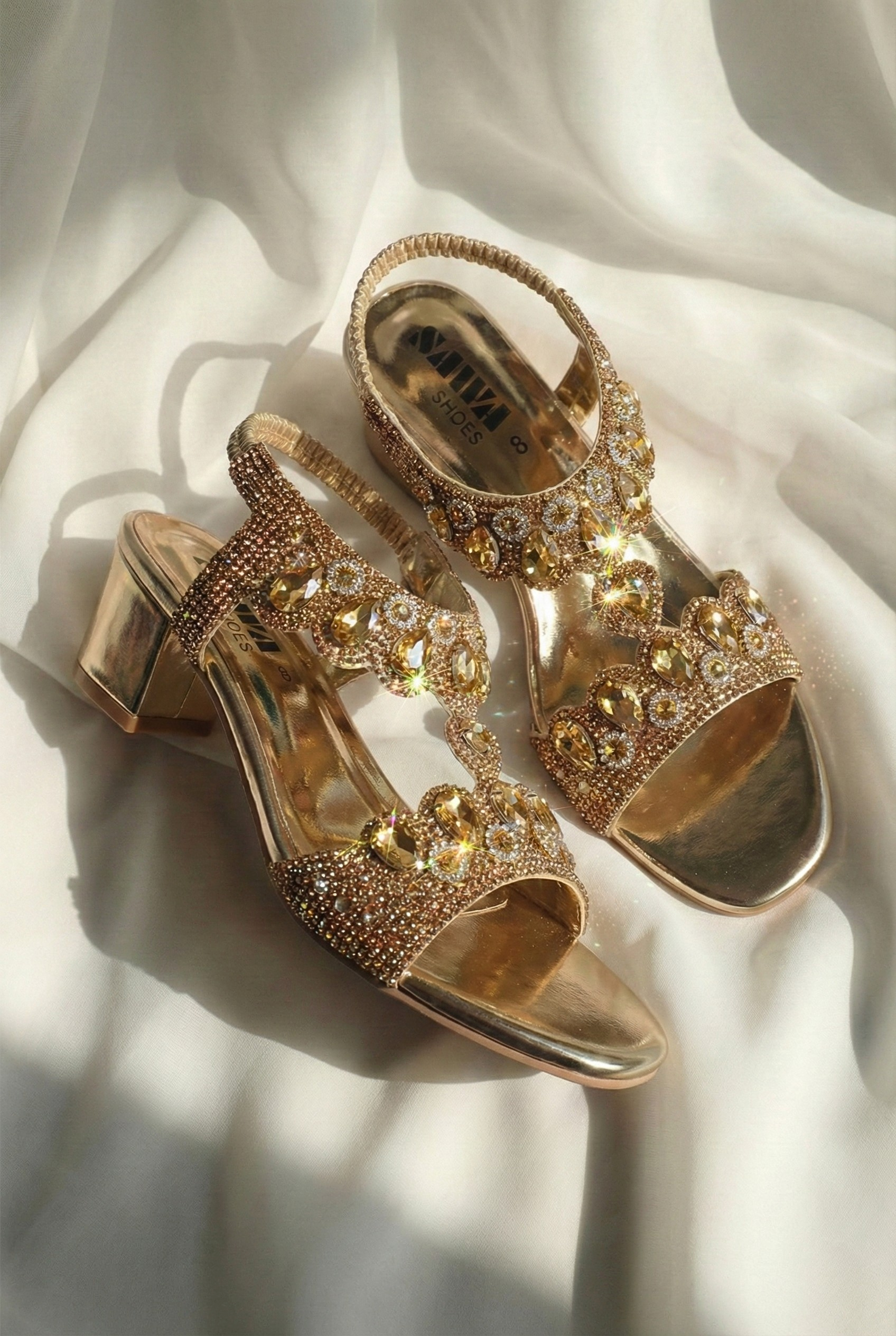 Side view of metallic gold block heel sandal featuring rhinestone straps and comfortable 2-inch heel for bridal wear.
