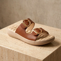 Cinnamon brown dual-strap slide sandals with gold buckles and molded beige sole