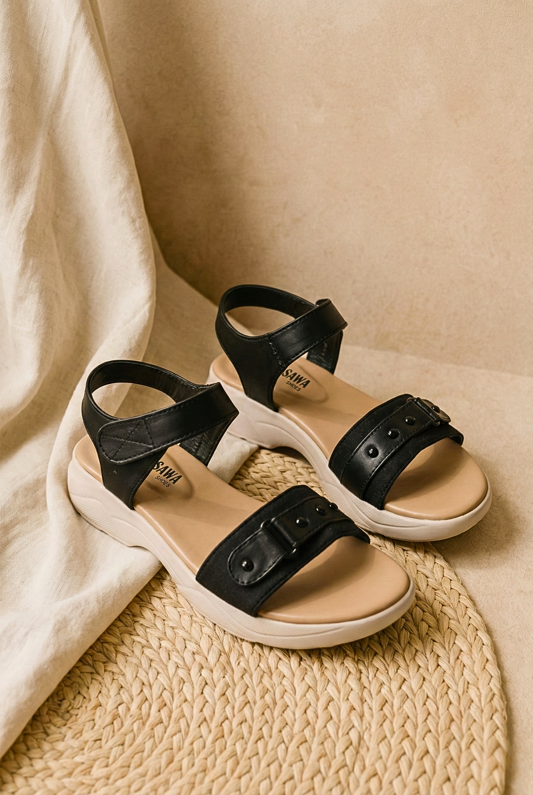 Side view of black comfort sandals with a thick beige contoured footbed and studded straps, priced at Rs. 2,390.