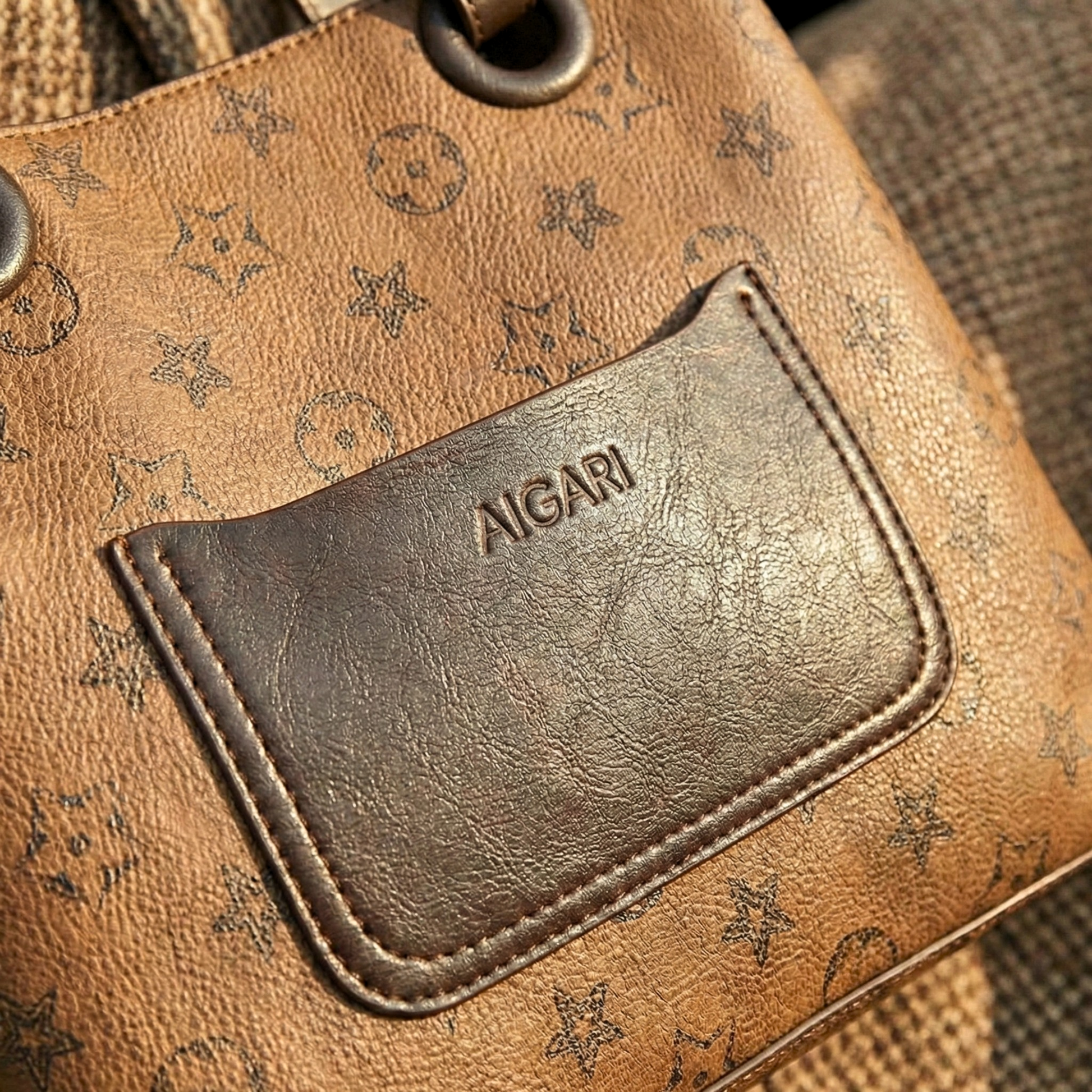 Detailed shot of textured synthetic leather and dark brown front pocket with star pattern