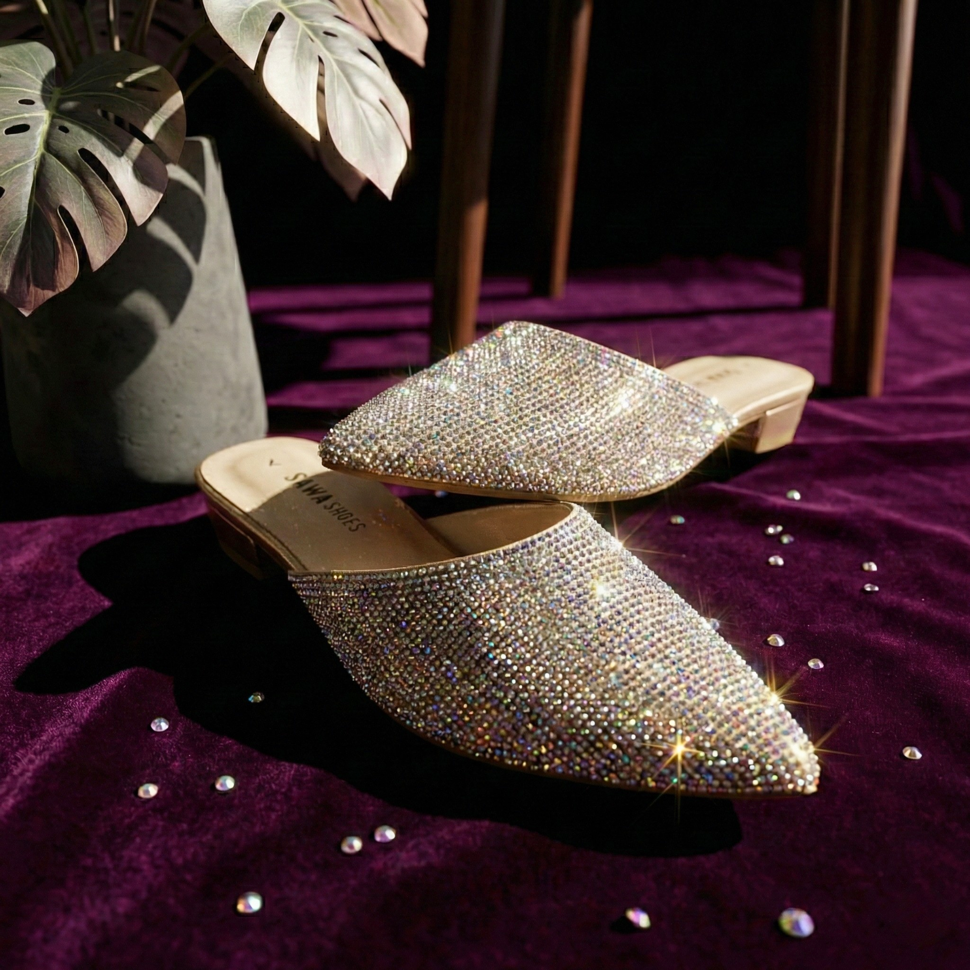 Pair of embellished shoes on a purple surface with decorative elements.