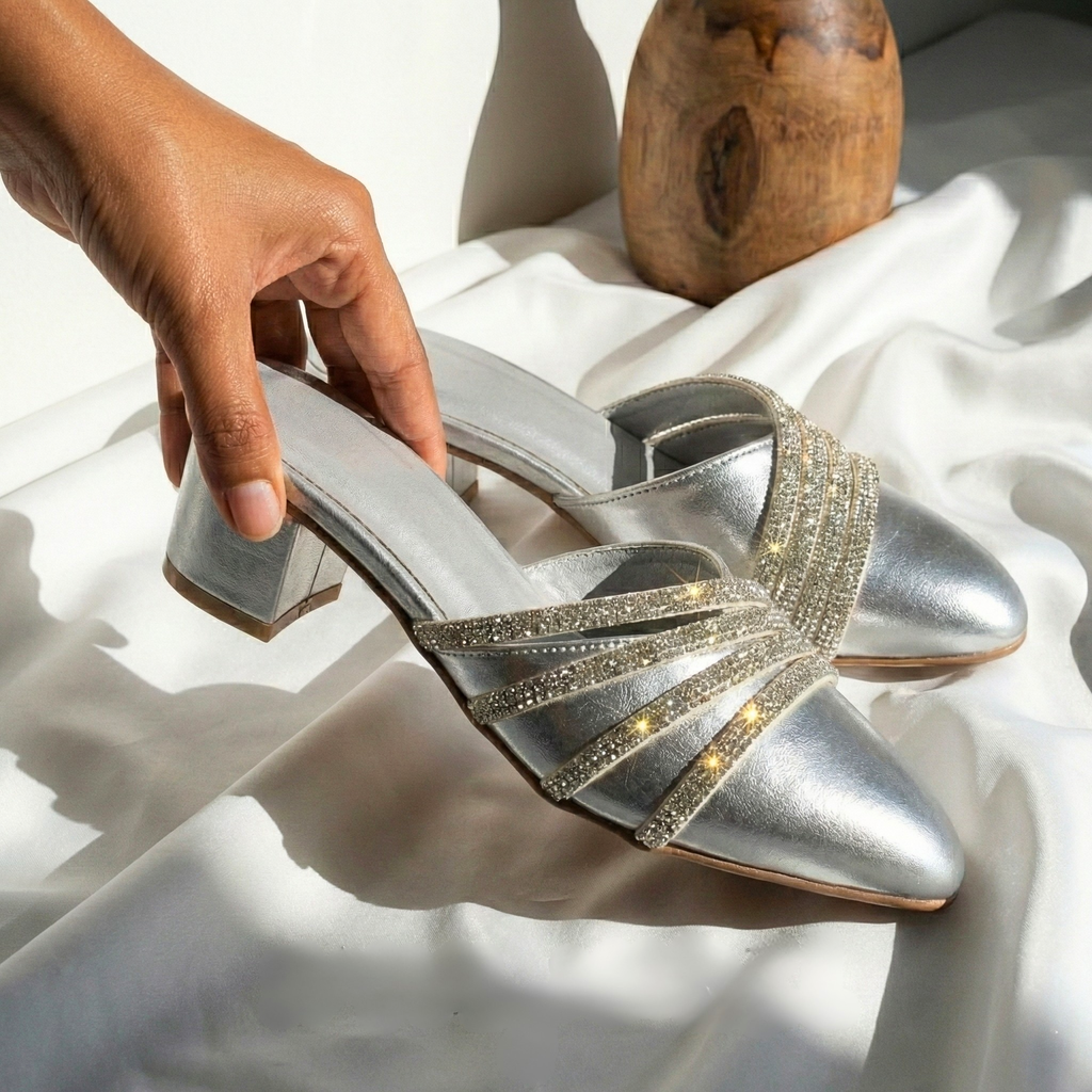Silver crystal encrusted pointed-toe mules with block heels for women on white silk background