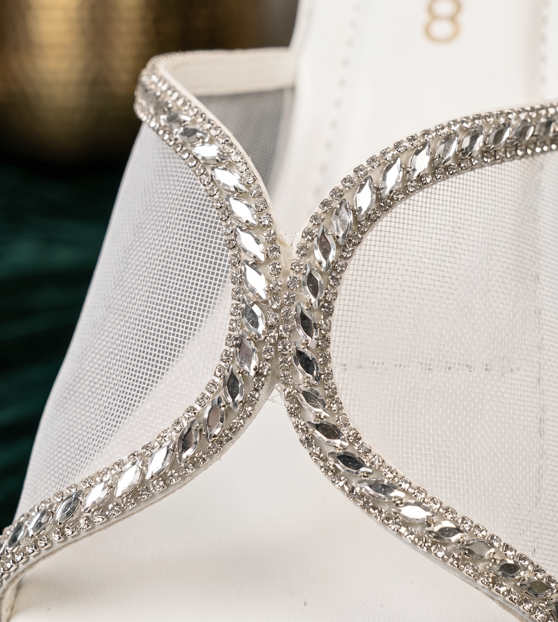 Close-up of white mesh sandal strap featuring intricate silver rhinestone crystal borders and marquise-cut gems