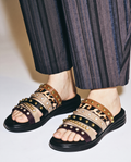 Multi-strap women's slide sandals featuring a leopard print band, studded leather-look straps, crystal accents, and a contoured black footbed
